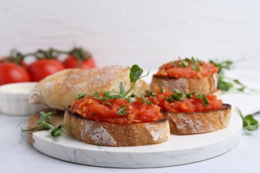 Domatesli lezzetli ekmek ve ışık masasında maydanoz, yakın çekim