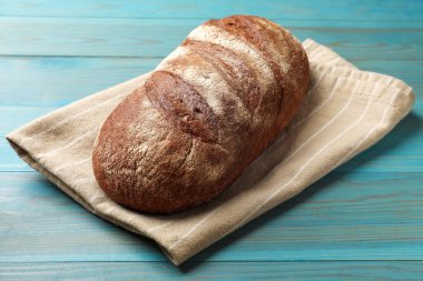 Açık mavi ahşap masada taze ekmek, yakın plan.