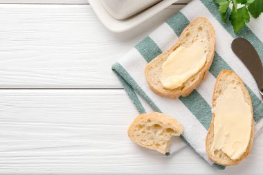 Beyaz ahşap masa üzerinde tereyağlı dilimler, düz uzanmış. Metin için boşluk