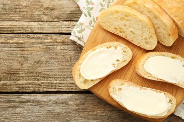 Tahta masa üzerinde tereyağlı ekmek parçaları, üst manzara. Metin için boşluk