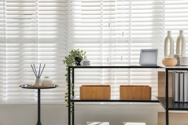 Pencerenin yanında farklı dekorları olan konsol masası. İç tasarım