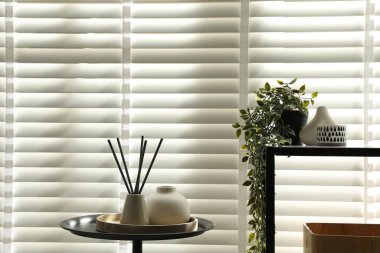 Pencerenin yanında farklı dekorları olan konsol masası. İç tasarım