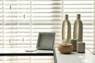 Pencerenin yanında farklı dekorları olan konsol masası. İç tasarım