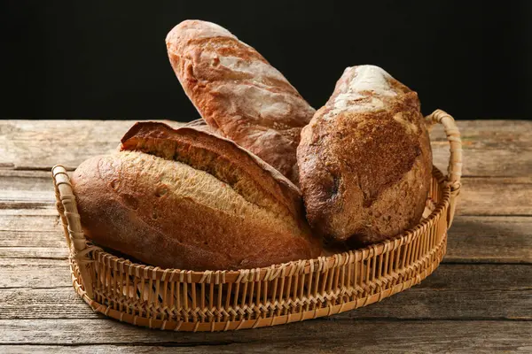 Tahta masadaki sepetin içinde farklı somunlar, yakın çekim.