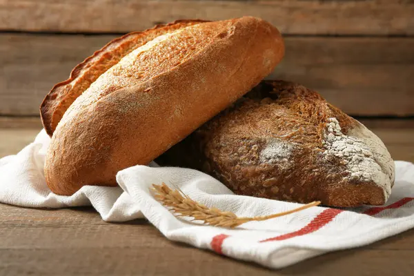 Taze pişmiş somunlar ve çiviler ahşap masada, yakın plan.