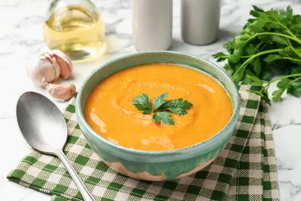 Beyaz mermer masada maydanozlu lezzetli mercimek kremalı çorba.