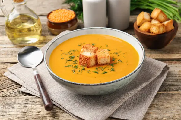 Tahta masada sunulan lezzetli mercimek kremalı çorba.