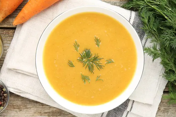 Ahşap masada servis edilen dereotlu mercimek kremalı leziz çorba.