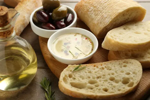 Ahşap masada yağlı, zeytinli ve baharatlı dilimlenmiş ekmek, yakın plan.