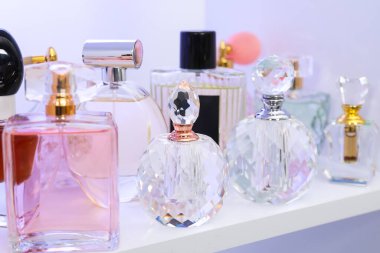 Dükkandaki raflarda farklı lüks parfüm şişeleri var.