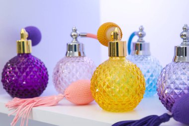 Dükkandaki raflarda farklı lüks parfüm şişeleri var.