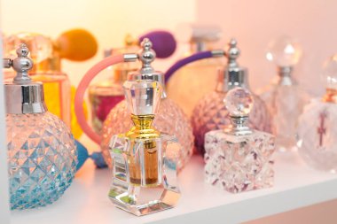 Dükkandaki raflarda farklı lüks parfüm şişeleri var.