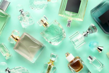 Turkuaz arka planda çeşitli parfüm şişeleri, düzlük