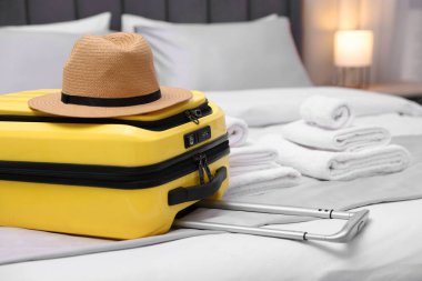 Otel odasında şapkalı bavul, yakın plan.