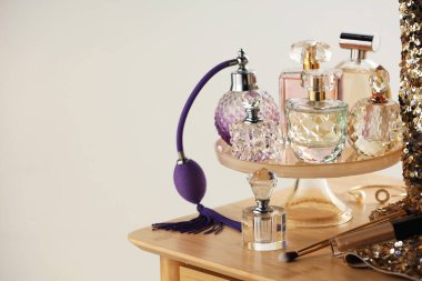 Odanın içinde ahşap tuvalet masasında farklı lüks parfümler, metin için yer.