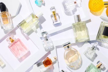 Beyaz arka planda farklı lüks parfümler, düz yatış