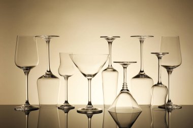 Ayna yüzeyinde bej arkaplana karşı birçok boş temiz bardak