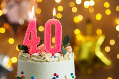 40. yaş günü. Yanan mumlar ve bulanık arka planda ışık ve yazı için yer olan lezzetli pastalar. Bokeh etkisi