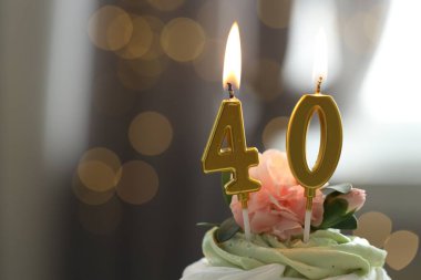 40. yaş günü. Bulanık arka planda yanan mumlar, ışıklar ve yazı için yer olan lezzetli bir kek. Bokeh etkisi