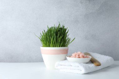 Beyaz masa üzerinde buğday otu ve deniz tuzu içeren spa kompozisyonu