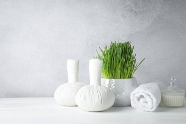Spa composition with wheatgrass on white table against light grey background. Space for text