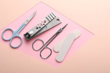 Renk arkaplanı üzerinde farklı manikür araçları kümesi, düz yatar