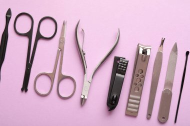 Pembe arka planda farklı manikür araçları, düz yatış