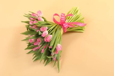 Bej arka planda güzel lalelerden oluşan bir buket.