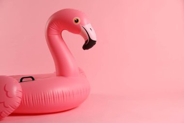 Pembe arkaplanda şişirilebilir flamingo şekilli halka, metin için boşluk