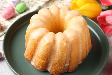 Lezzetli kek, Paskalya yumurtası ve laleler masada, yakın plan.