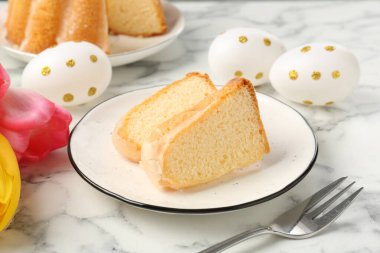 Lezzetli kek parçaları, Paskalya yumurtaları ve laleler açık mermer masada, yakın plan.