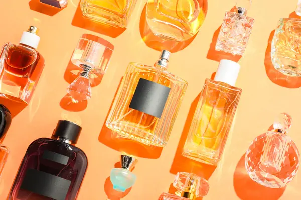 Bej arka planda farklı lüks parfümler, düz yatış