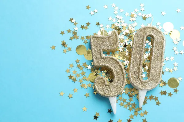 50. yaş günü. Açık mavi arkaplandaki mumlar ve konfetiler düzdü. Metin için boşluk