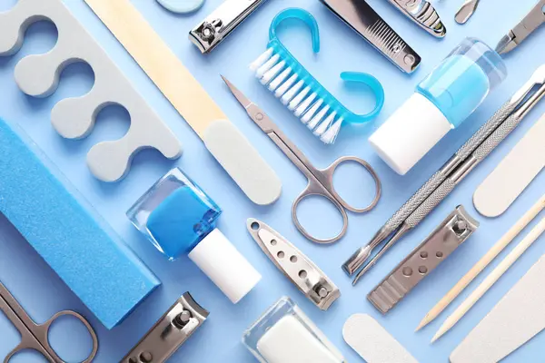 Açık mavi zemin üzerinde farklı manikür araçları kümesi, düz yatıyordu