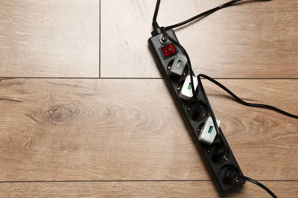 Uzatma güç panosu ahşap zemin ve üst manzara tıkaçlarıyla aşırı yüklenmiş. Metin için boşluk