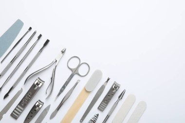 Beyaz arka planda farklı manikür aletleri var. Metin için boşluk