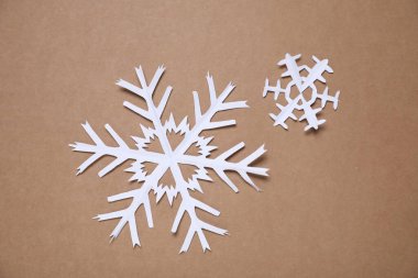 Kahverengi arka planda güzel kar taneleri, düz uzanmış.