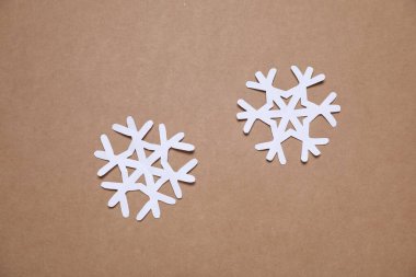 Kahverengi arka planda güzel kar taneleri, düz uzanmış.