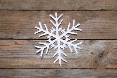 Tahta arka planda bir kar tanesi, üst manzara.