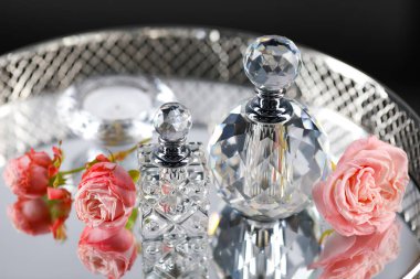 Metal tepside parfüm şişeleri ve çiçekler, yakın plan.