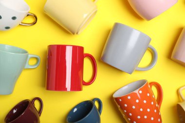 Sarı arkaplanda bir sürü renkli fincanlar var.