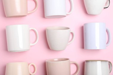 Pembe arka planda bir sürü renkli fincanlar var.