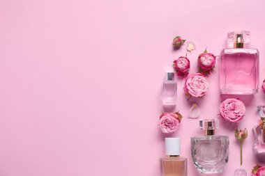 Parfüm şişeleri ve pembe arka planda güzel çiçekler. Metin için boşluk