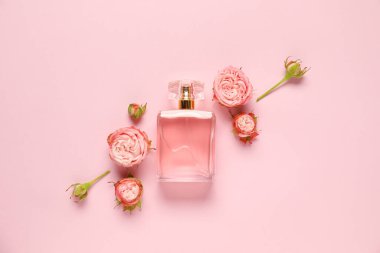 Parfüm şişeleri ve pembe arka planda güzel çiçekler.
