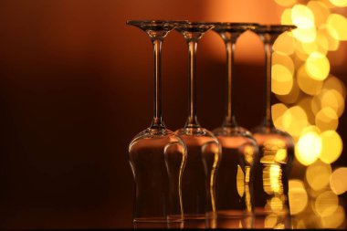 Bulanık ışıklara karşı cam ayna yüzeyinde birçok temiz bardak var. Bokeh etkisi