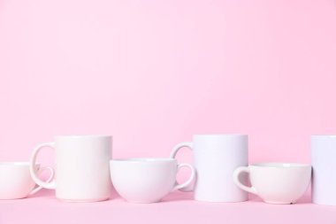 Pembe arka planda farklı bardaklar. Metin için boşluk