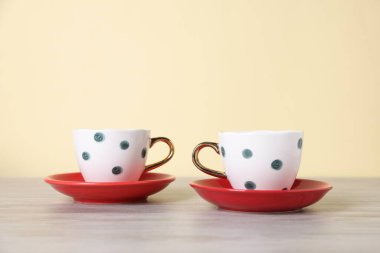 Güzel fincanlar ve tabaklar bej arka planda açık ahşap masa üzerinde