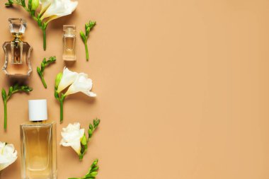 Düz kompozisyonda aromatik parfüm şişeleri ve bej arka planda güzel çiçekler vardı. Metin için boşluk
