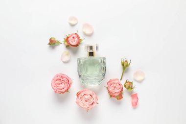 Aromatik parfüm şişeleri ve beyaz arka planda güzel çiçekler.