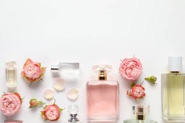 Kokulu parfüm şişeleri ve beyaz arka planda güzel çiçekler. Metin için boşluk